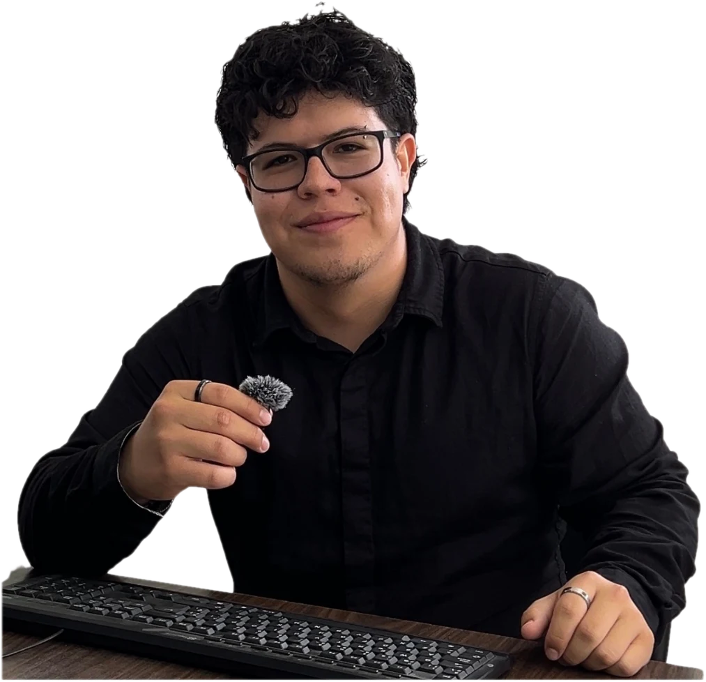 Yosef Puetate sonriendo, sentado frente a un teclado, con camisa negra