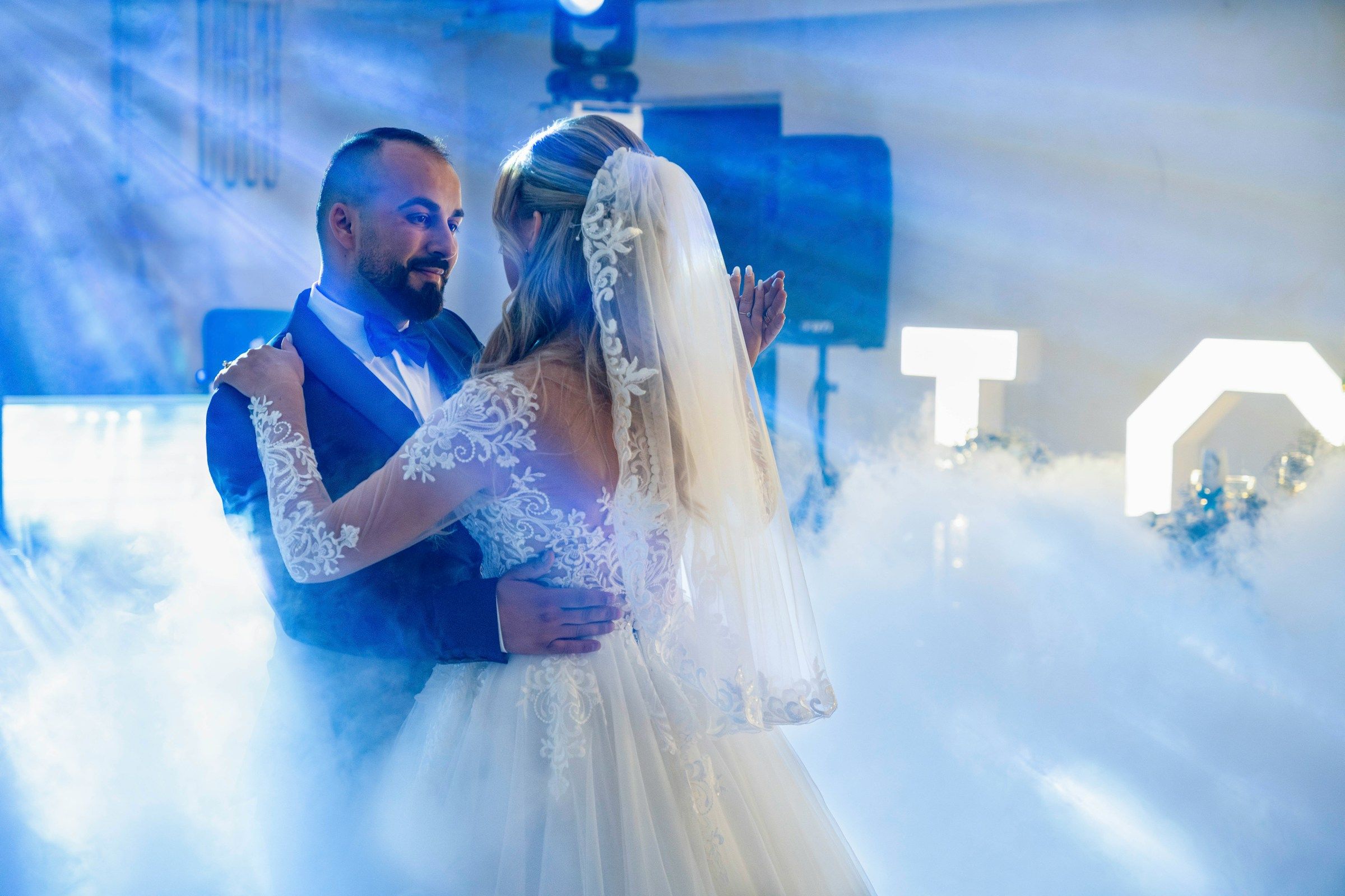 Novios bailando el vals entre humo bajo con luces frías
