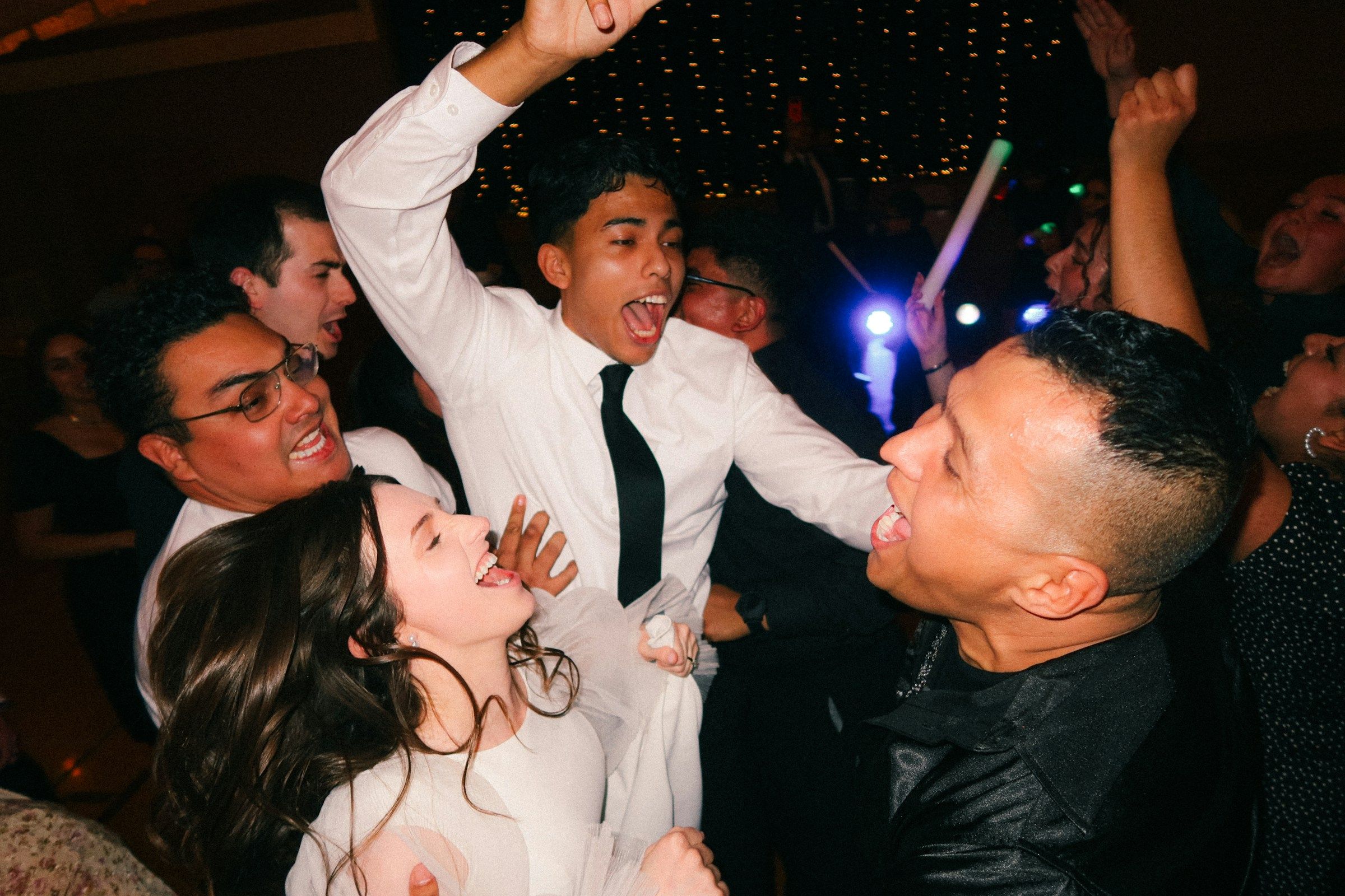Novios e invitados bailando en la pista de una boda bajo una carpa